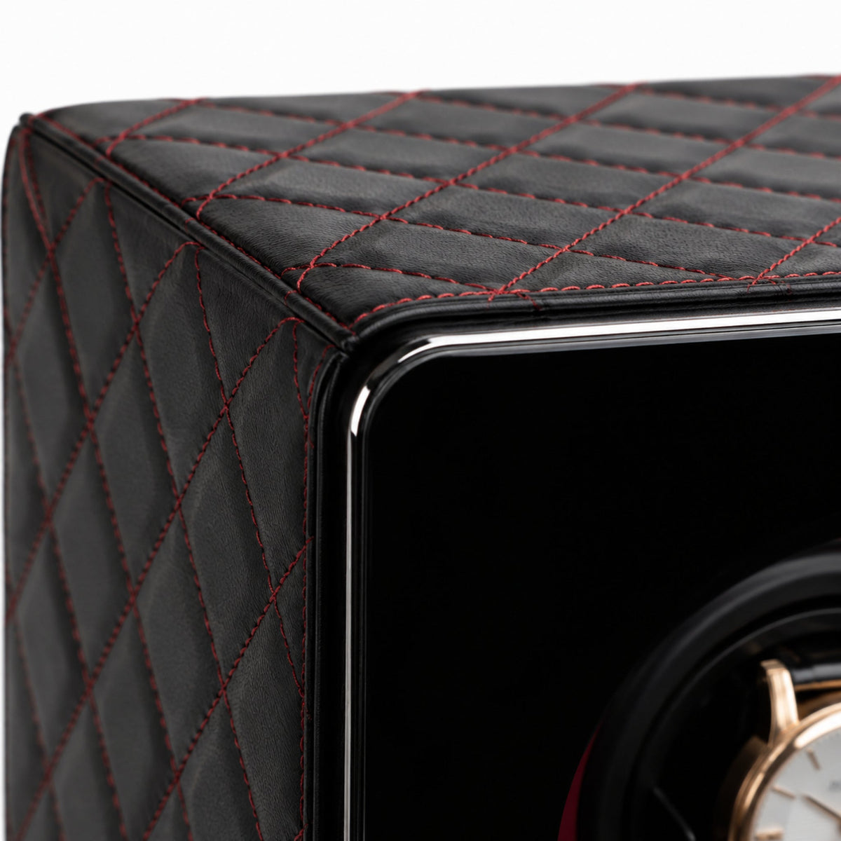 Détail macro du cuir noir capitonné, surpiqûres rouges et arête chromée du Polaris — Maison Orvian